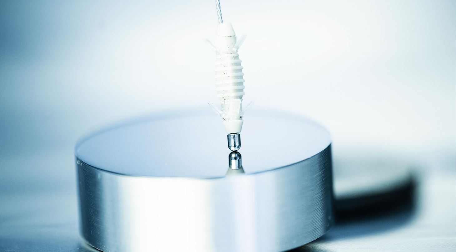 Close-up af metalemne med blank overflade - wire berører den